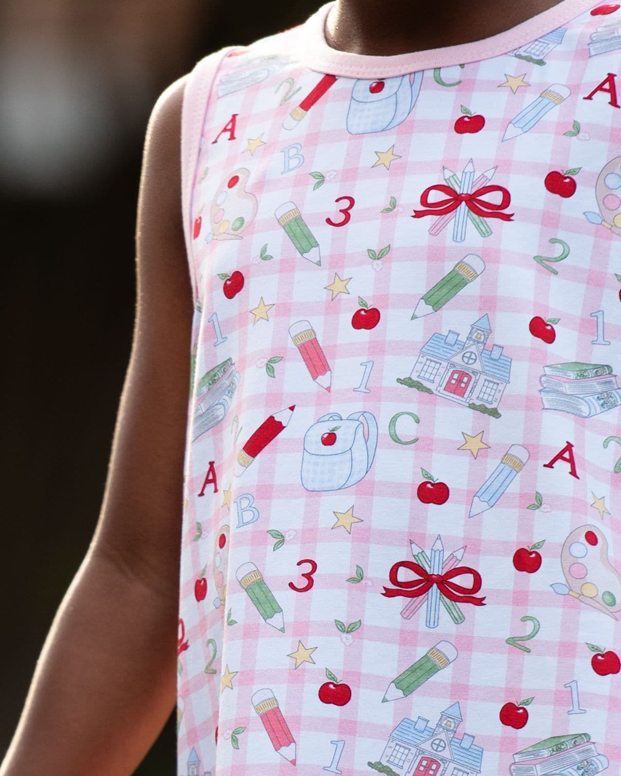 Close up of a young child wearing a school themed outfit. 
