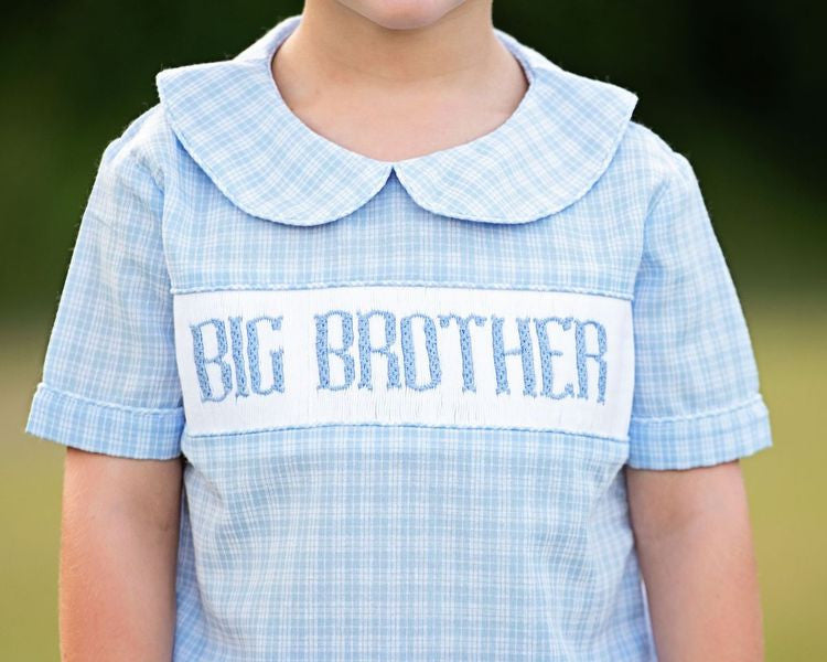 Close up of blue plaid shirt with big brother smocked across the chest