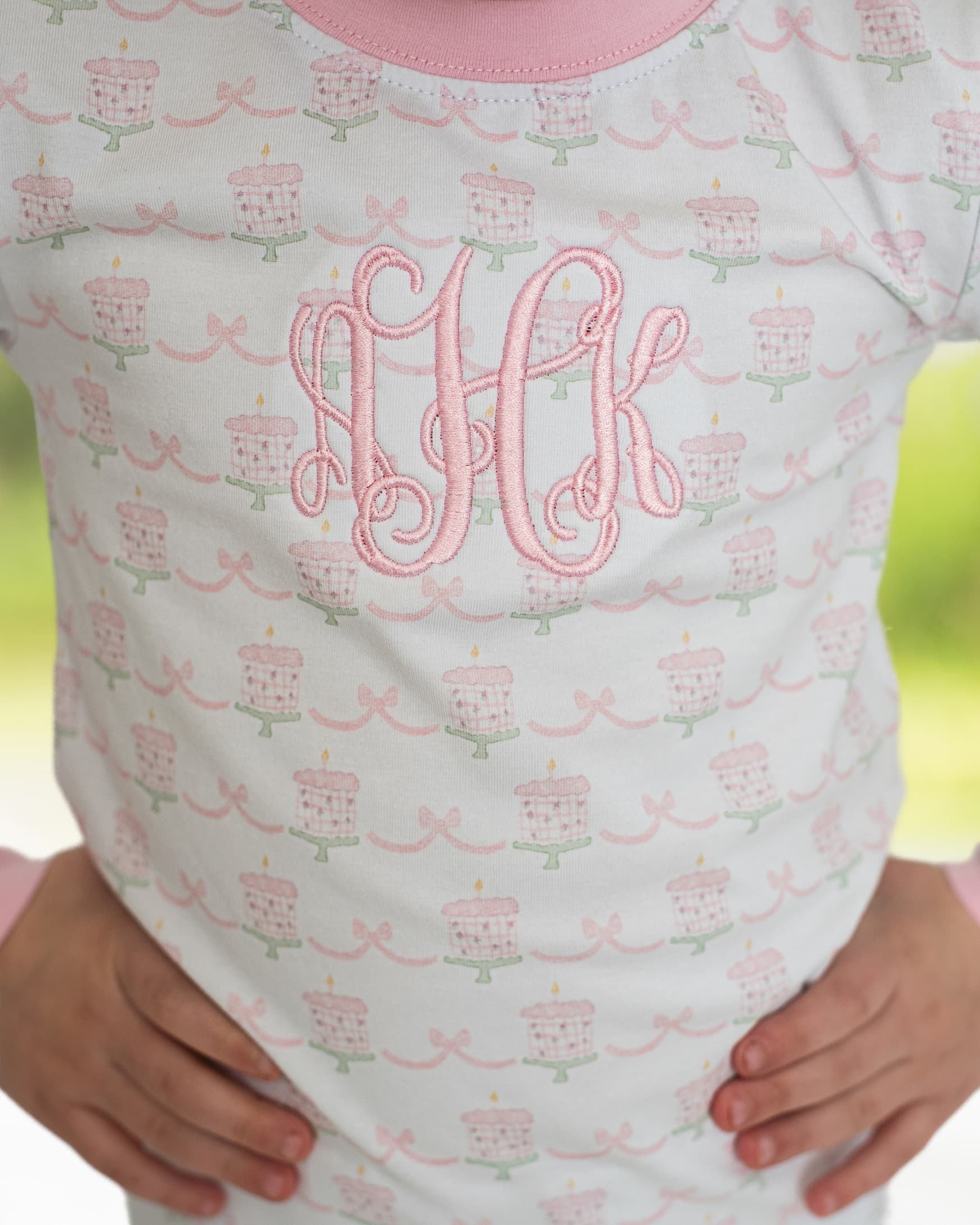 Close up of pajamas with birthday cakes and bows. 