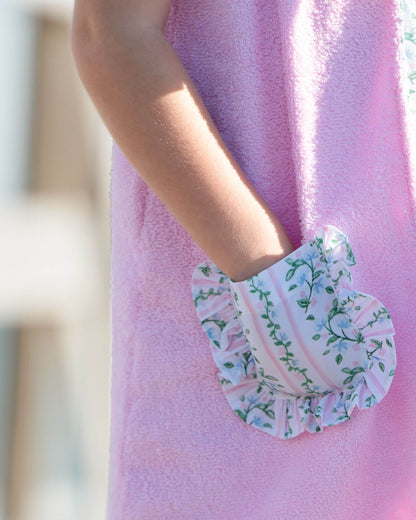 Closeup of a pink terry coverup with floral pocket detail.