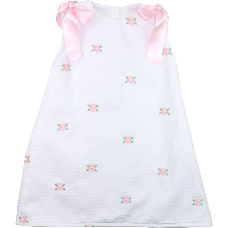 White dress with pink floral embroidery and ribbons on a white background