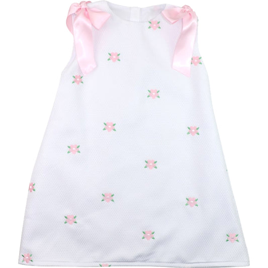 White dress with pink floral embroidery and ribbons on a white background