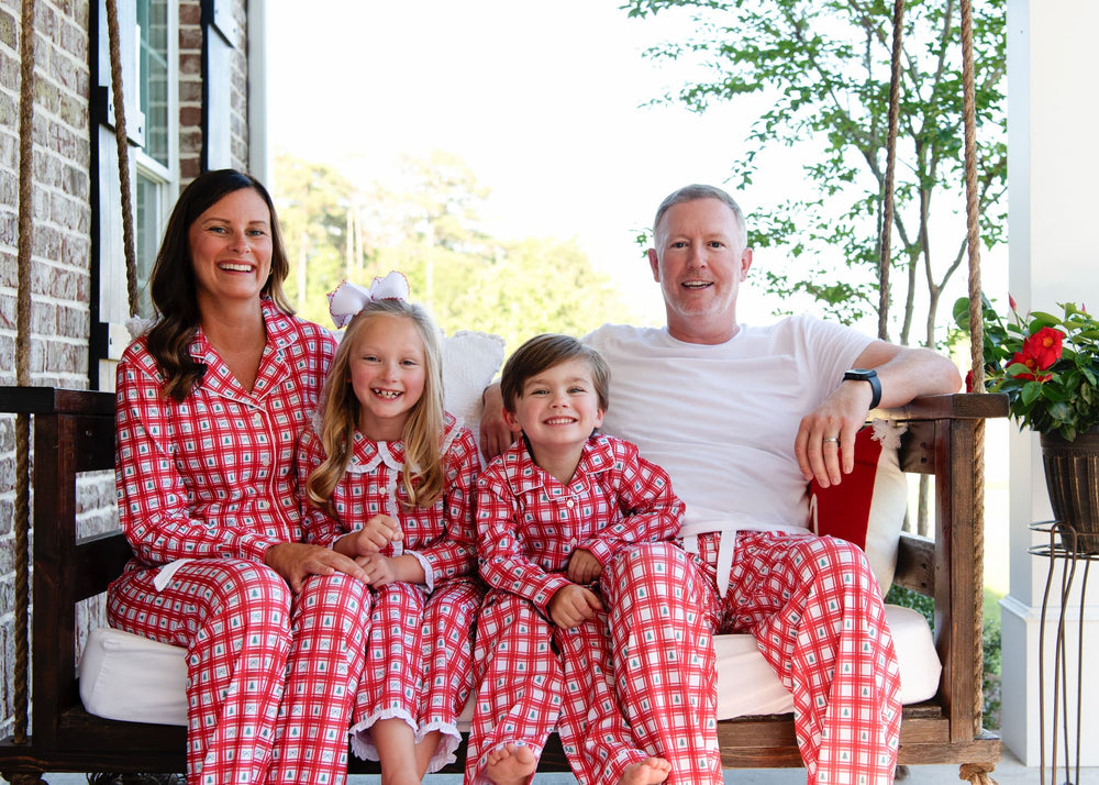 Family of four wearing coordinated Christmas pajamas
