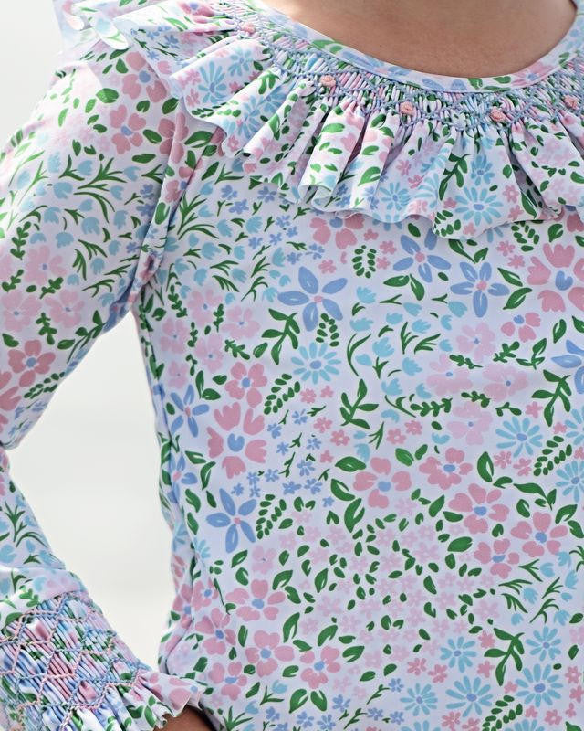 Floral patterned rashguard with smocking and a white background