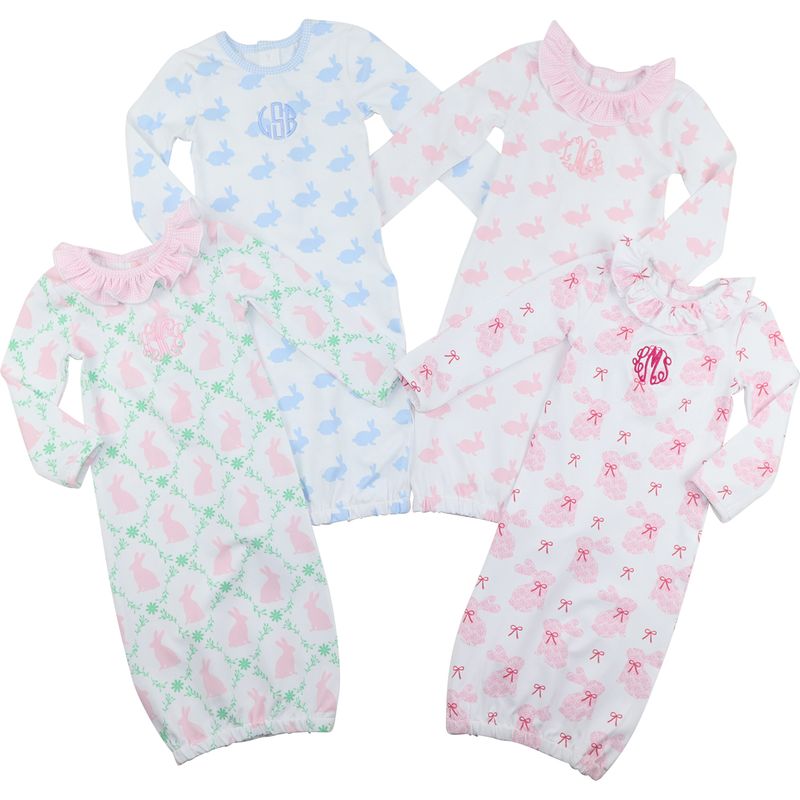Four baby gowns with different patterns on a white background