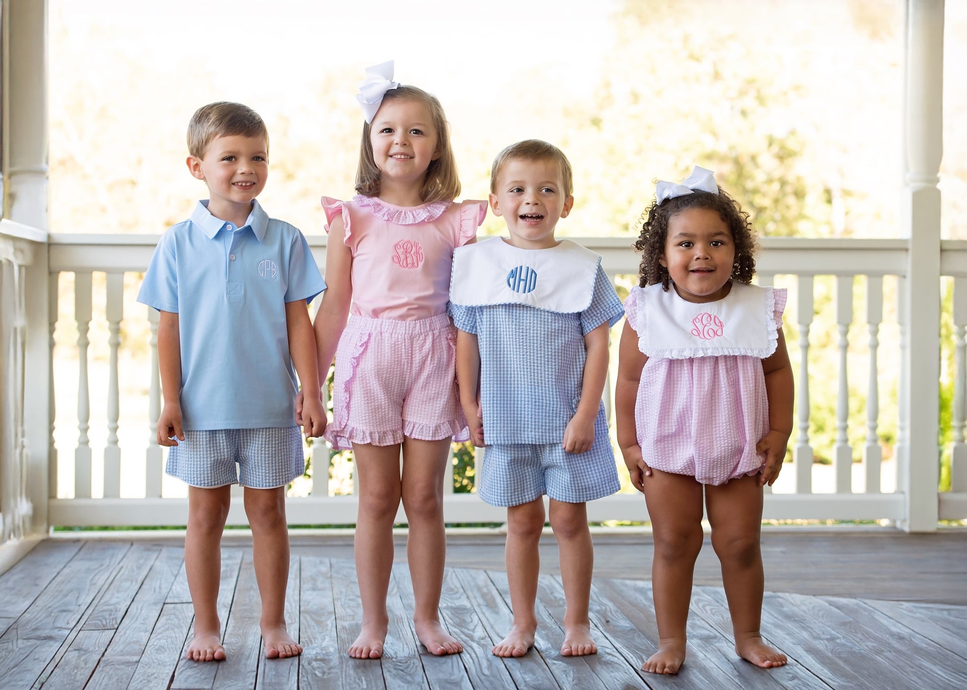 Four children wearing matching outfits on a wooden deck.