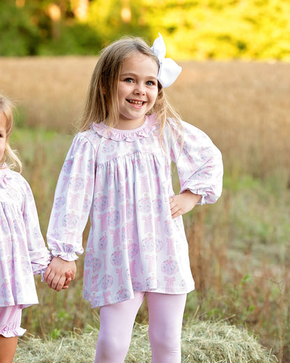 Girl holding hand in pink floral pumpkin legging set 