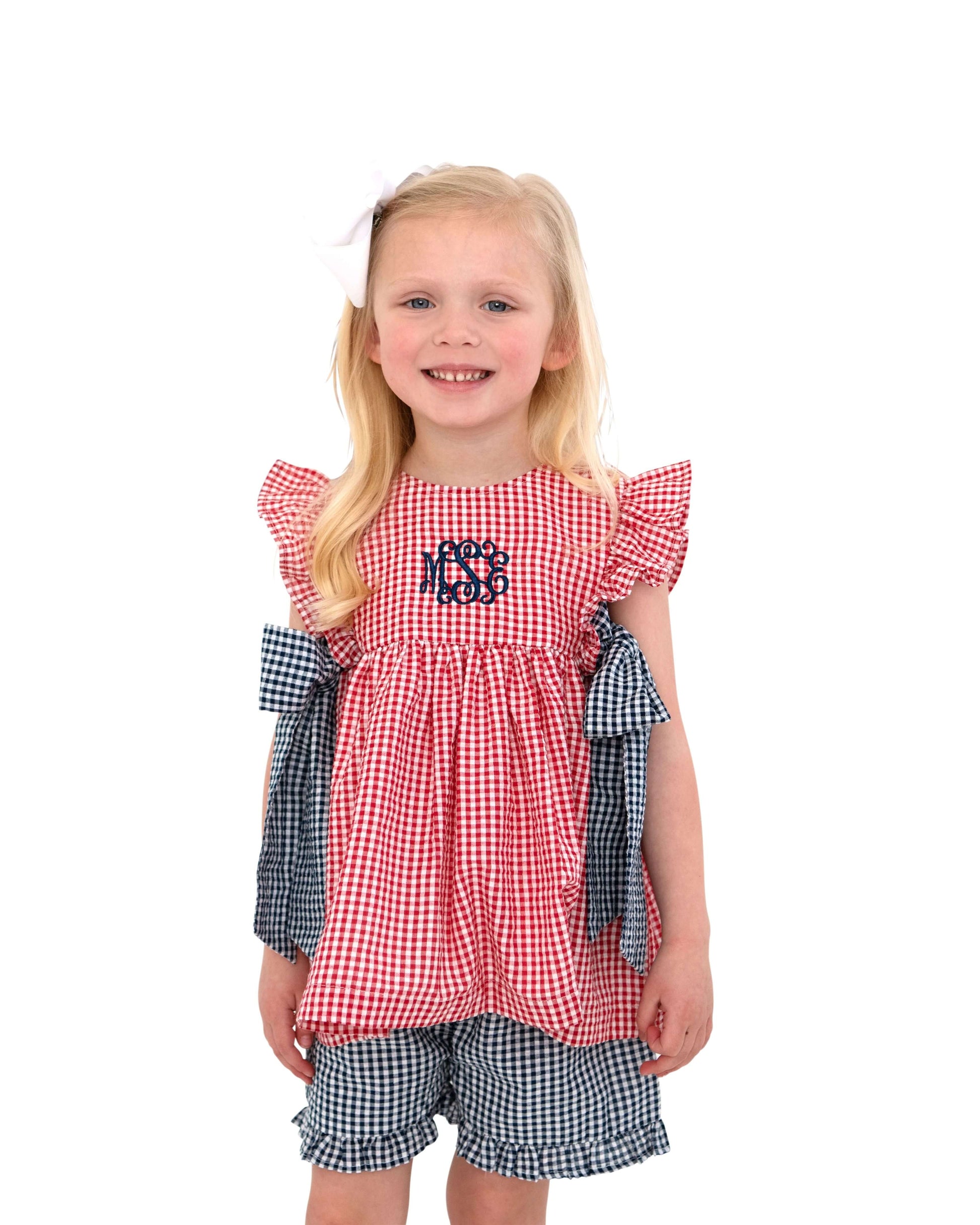 Girl_in_red_and_navy_checkered_outfit_in_a_studio.