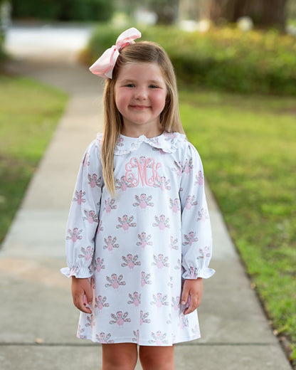 Girl standing on a sidewalk wearing a dress with turkeys on it