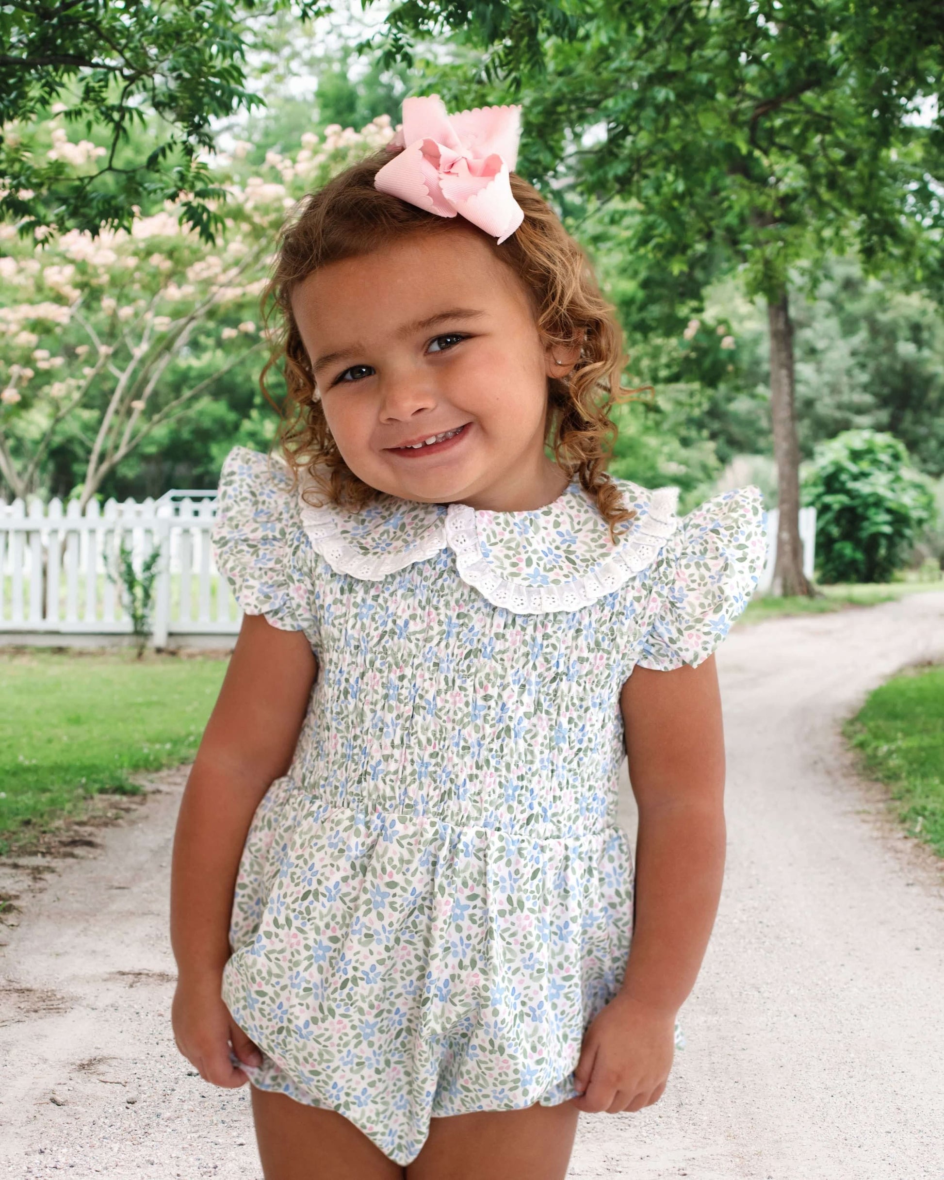 Girl wearing a floral outfit and pink bow