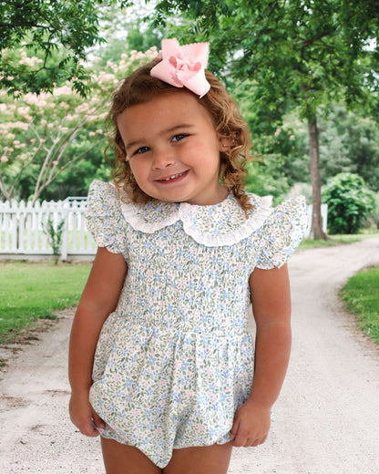 Girl wearing a floral outfit and pink bow