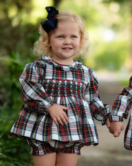 Girl wearing a plaid outfit, smiling 