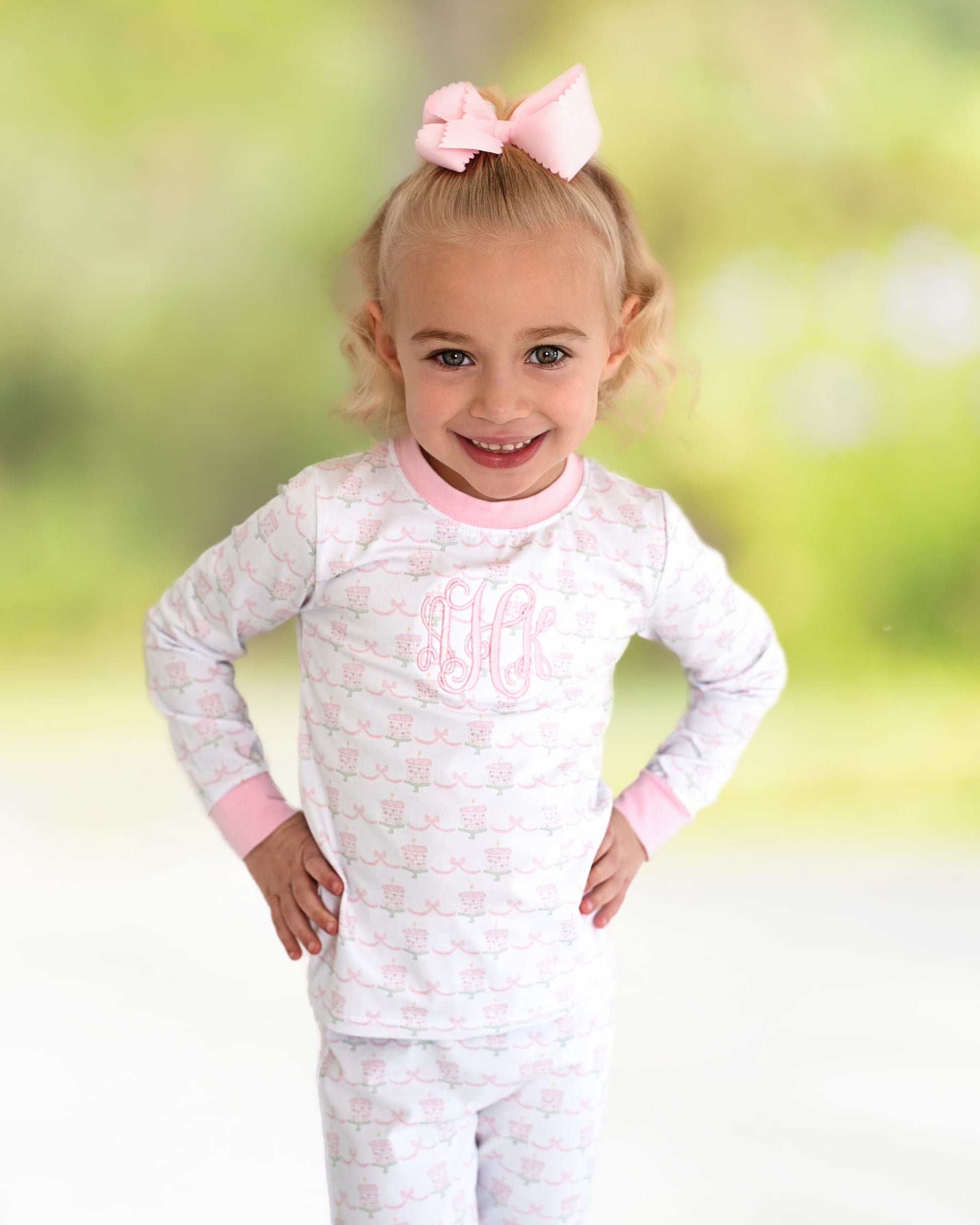 Girl wearing pajamas with hands on her hips smiling. 
