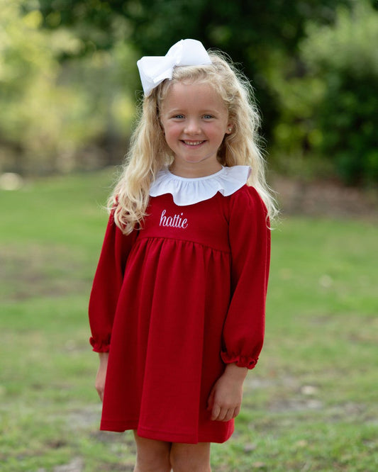 Girl with blonde hair wearing a red dress with a white bow