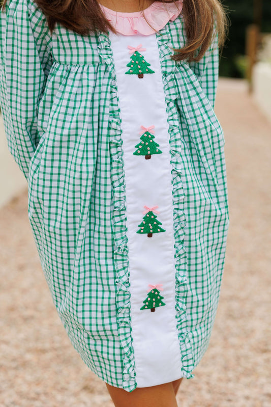 Green checkered dress with embroidered Christmas trees on a blurred background