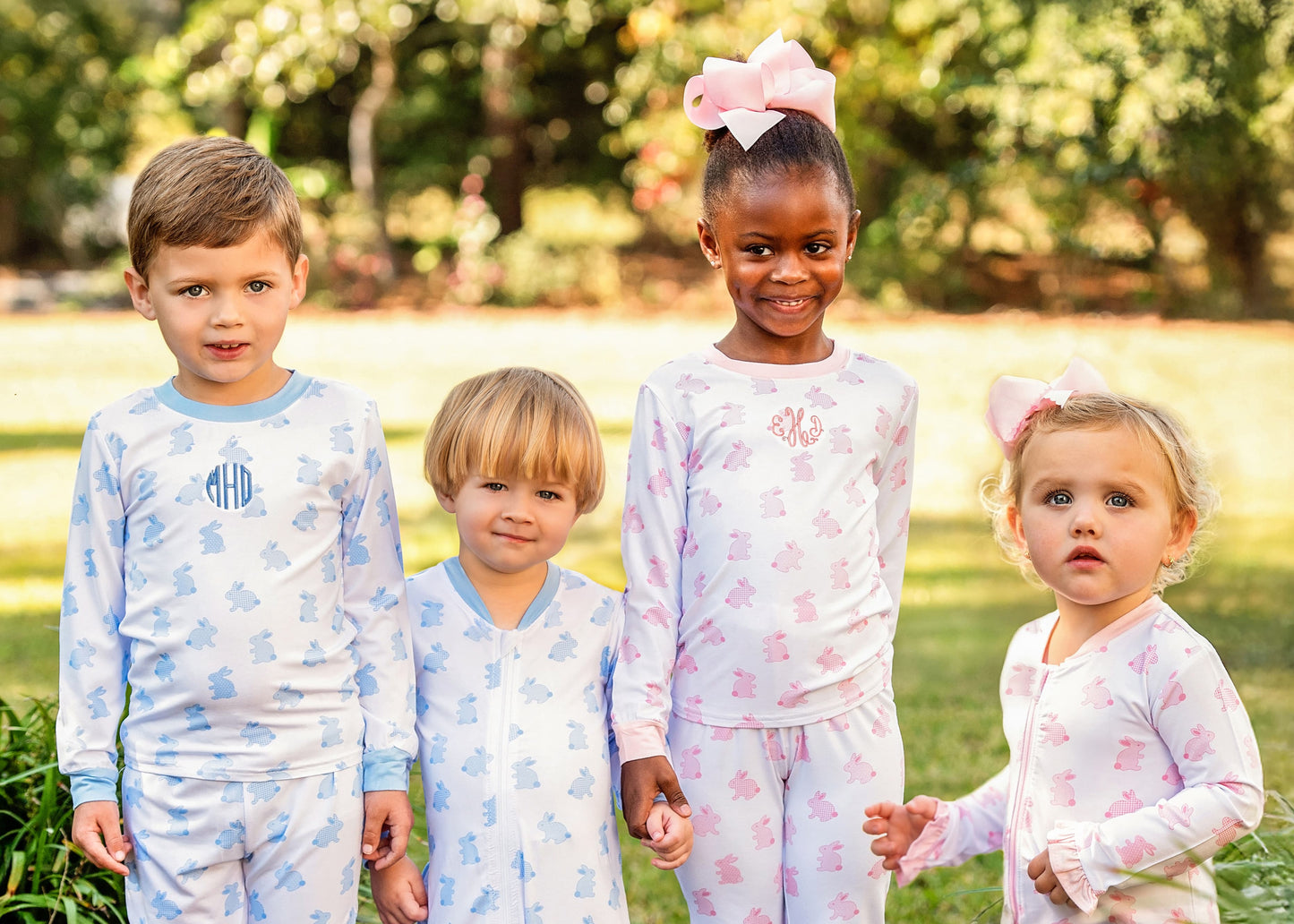 Four children wearing matching pajamas in a park setting