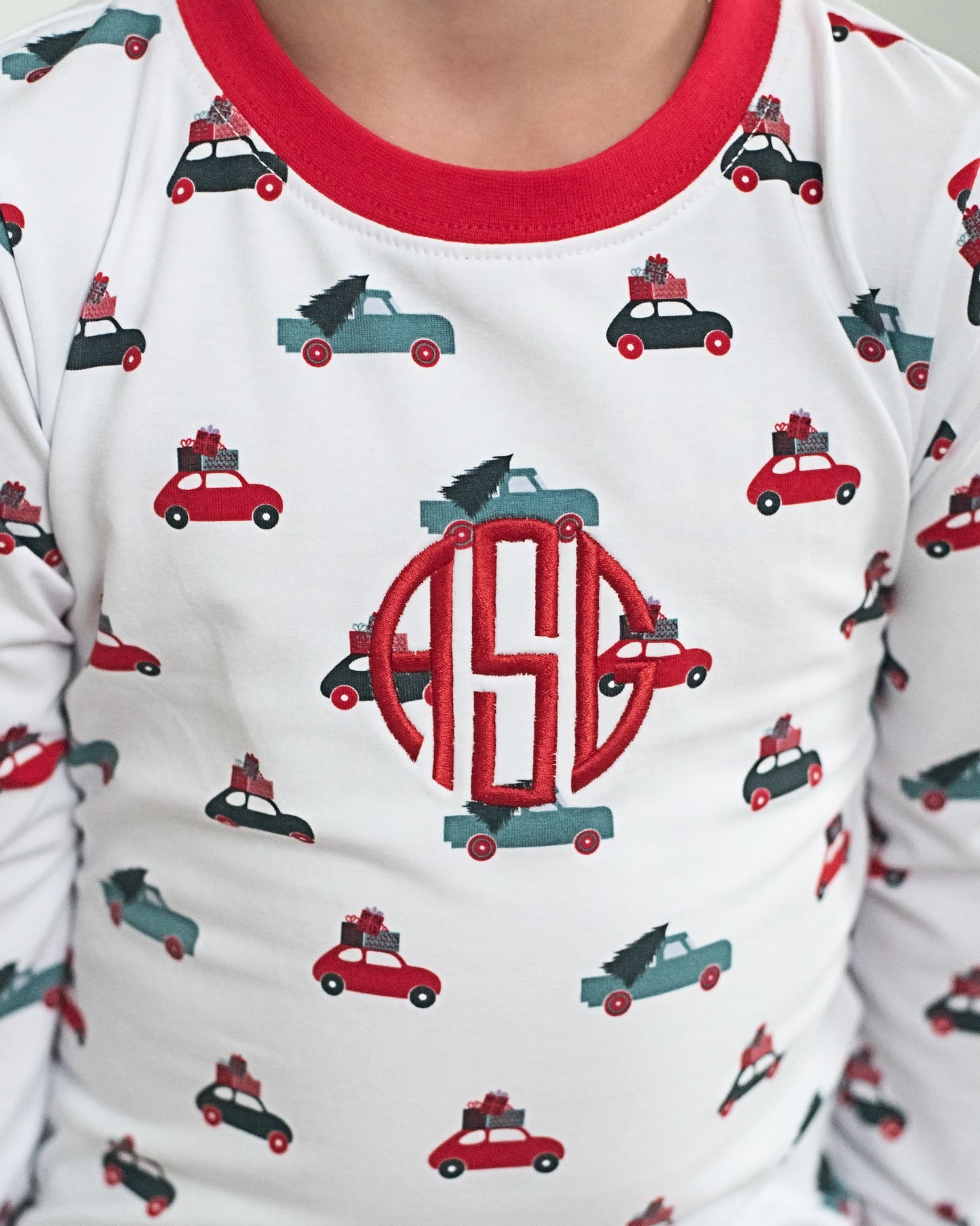 Children's pajama top with car pattern and monogram on a white background