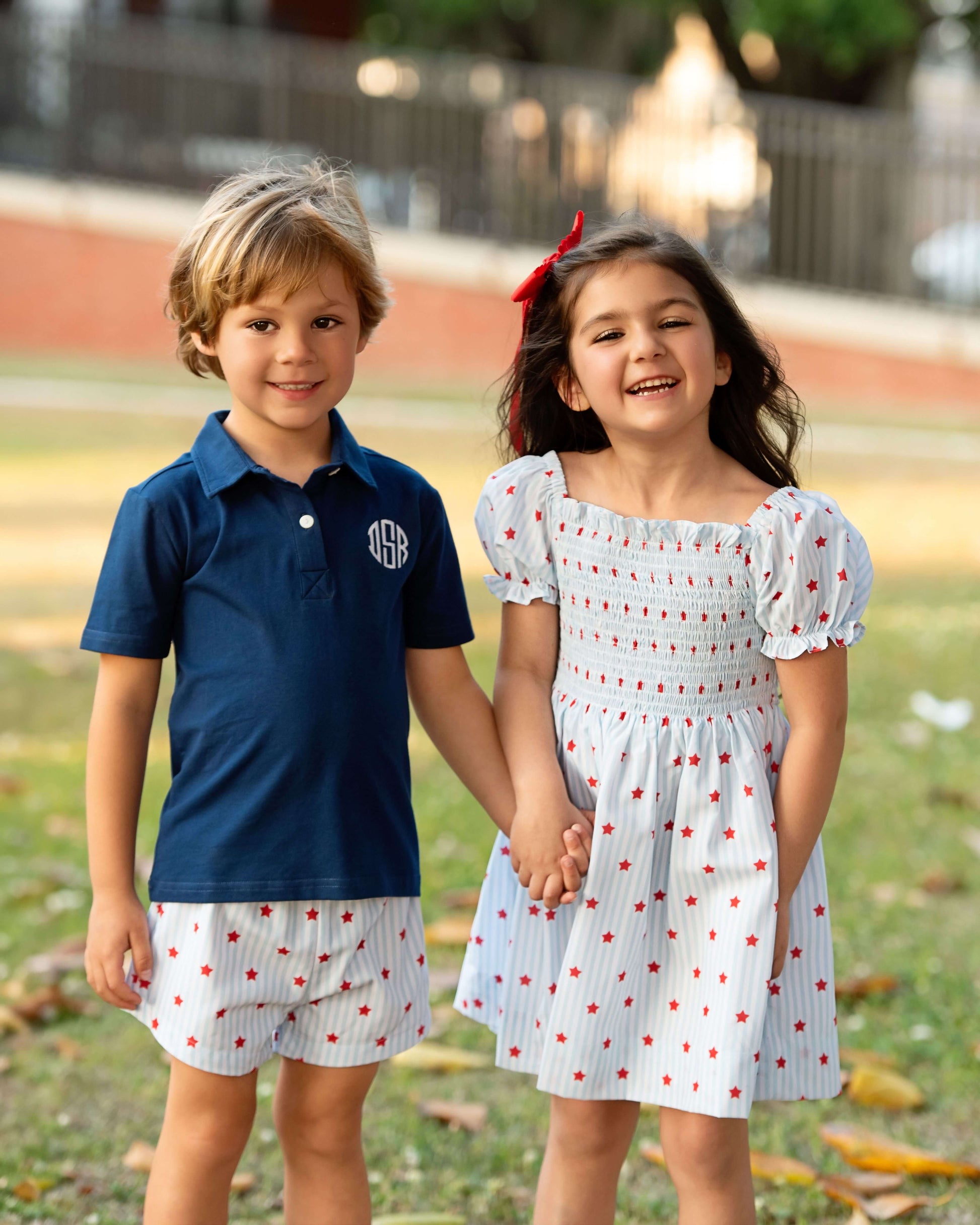Kids in matching outfits holding hands smiling