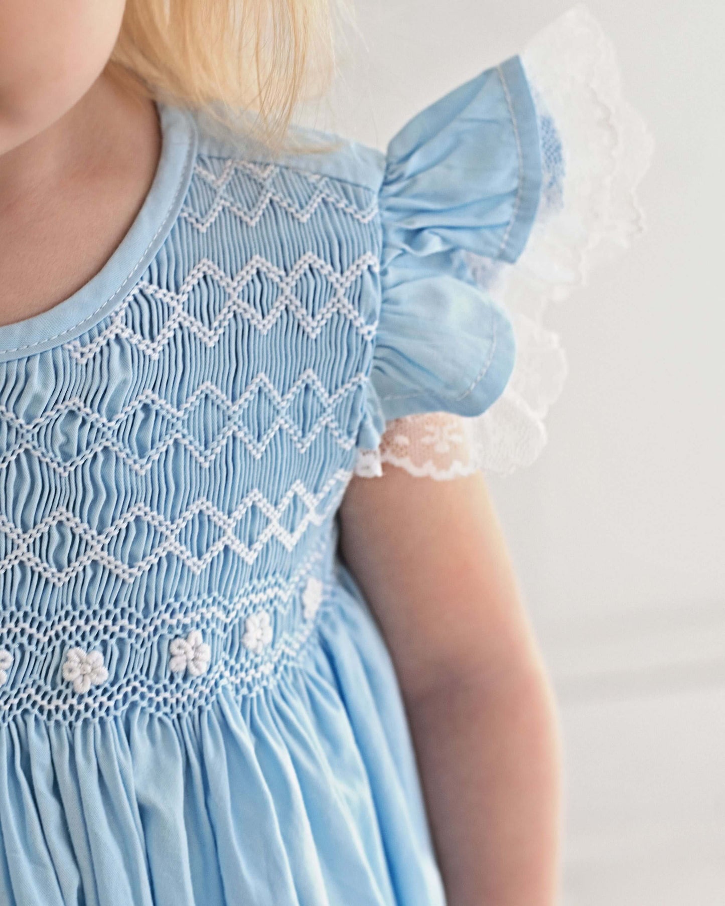 Light blue dress with intricate white patterns on a plain background