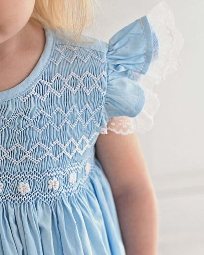 Light blue dress with intricate white patterns on a plain background