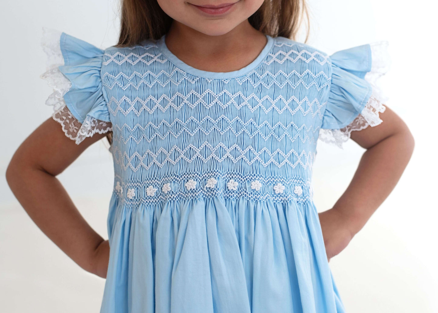 Light blue dress with lace details on a white background