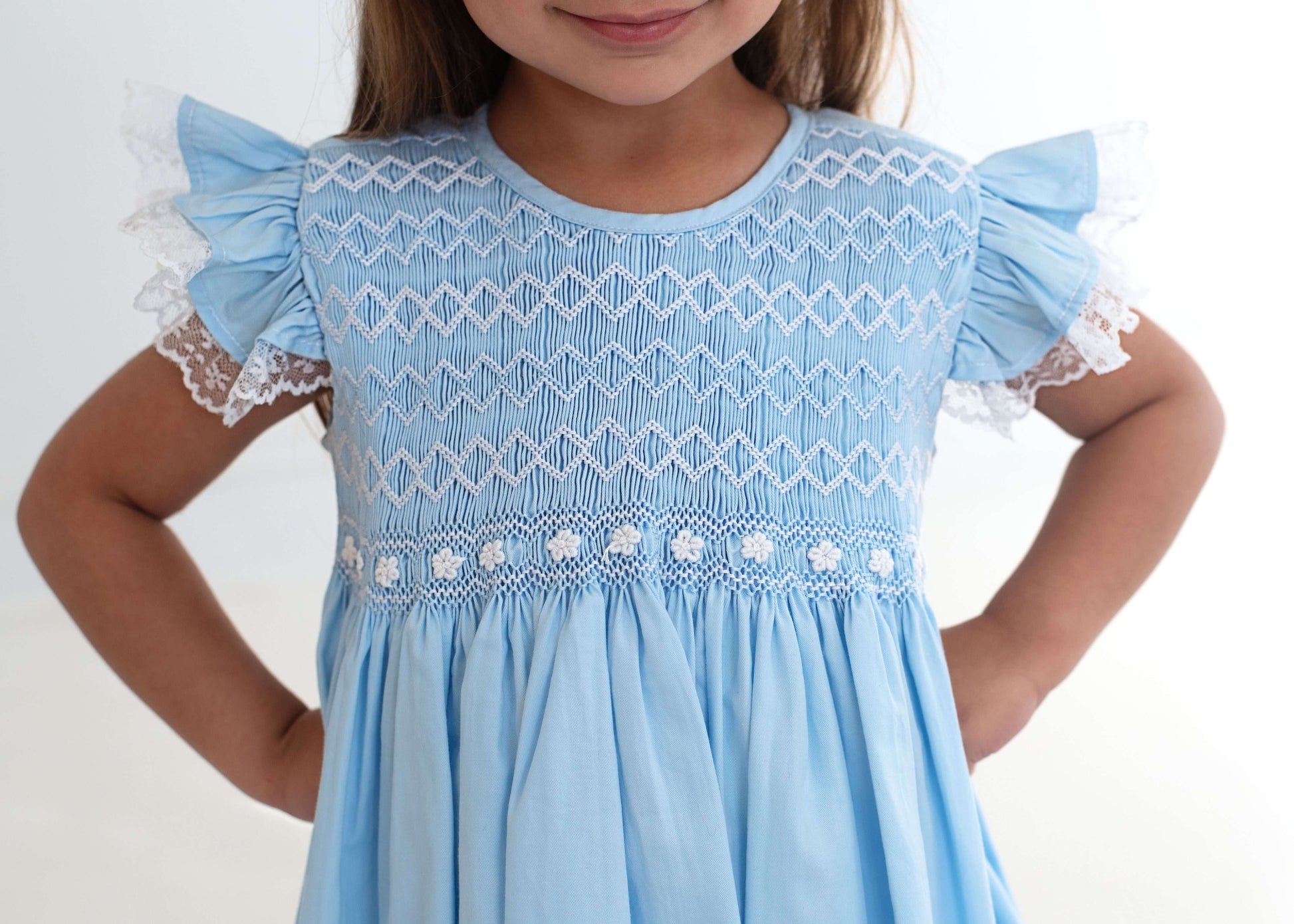 Light blue dress with lace details on a white background
