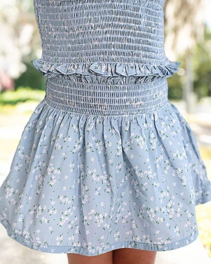 Light blue floral skirt set with a blurred outdoor background