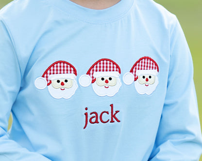 Light blue shirt with three cartoon Santa faces and the name 'jack' on a green background