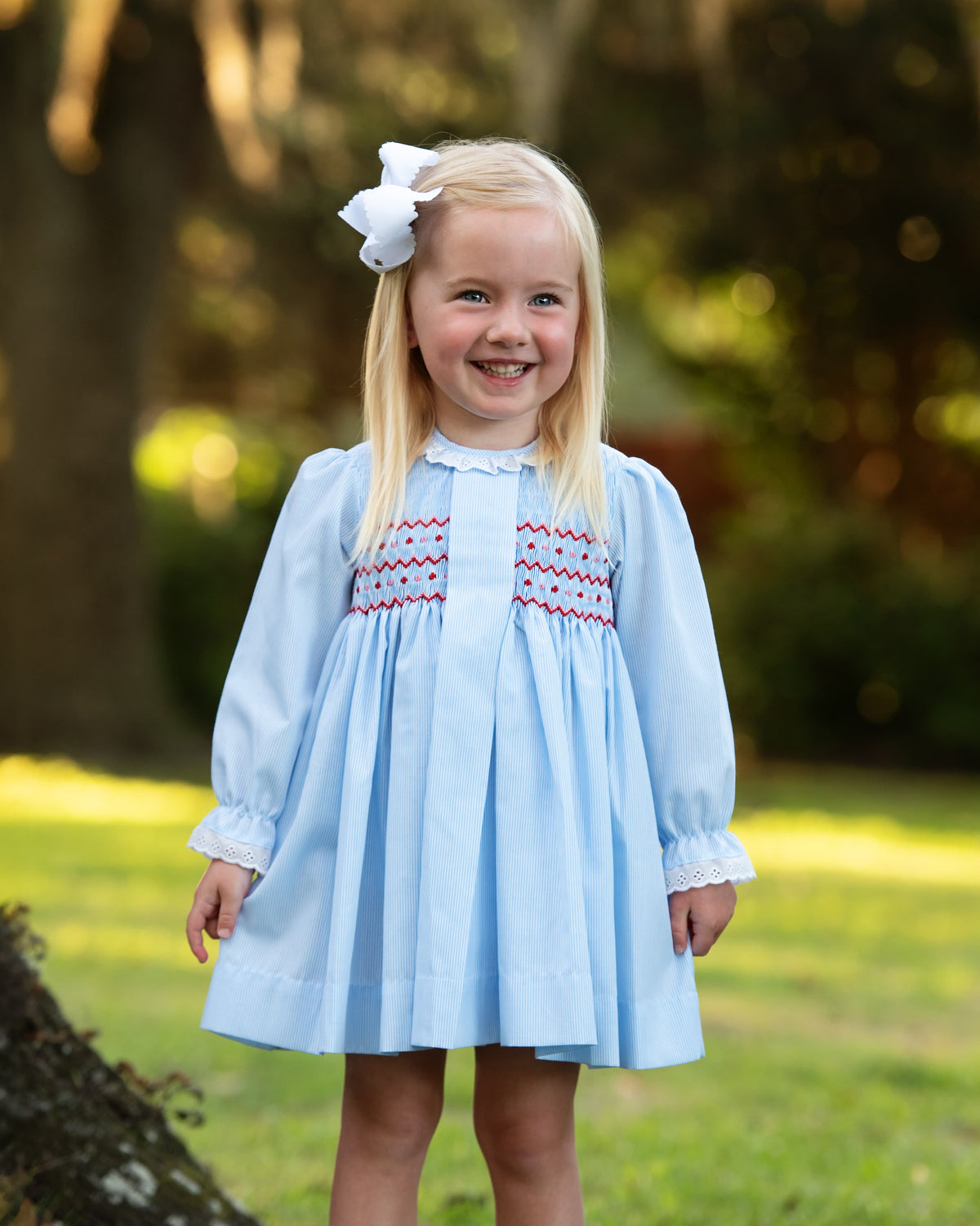 Girl wearing the Blue Pique Geometric Smocked Dress outdoors