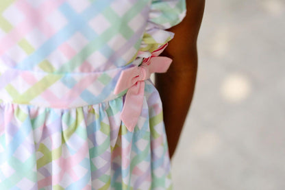 Pastel checkered dress with a bow detail on a blurred background