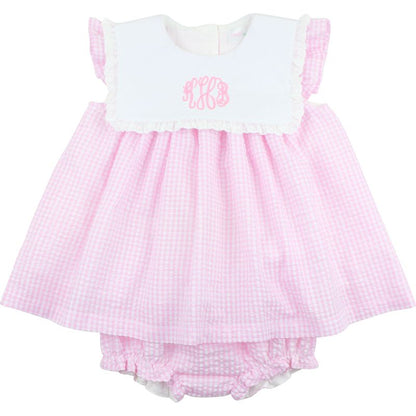 Pink checkered baby dress with white top on a white background