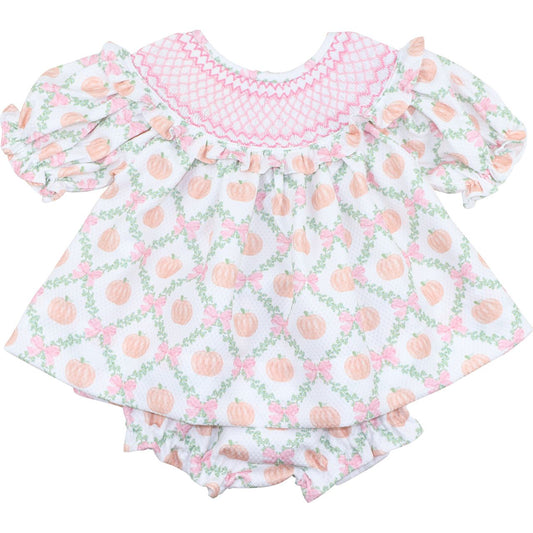 girl's diaper set with pink smocking and peach patterned dress on a white background