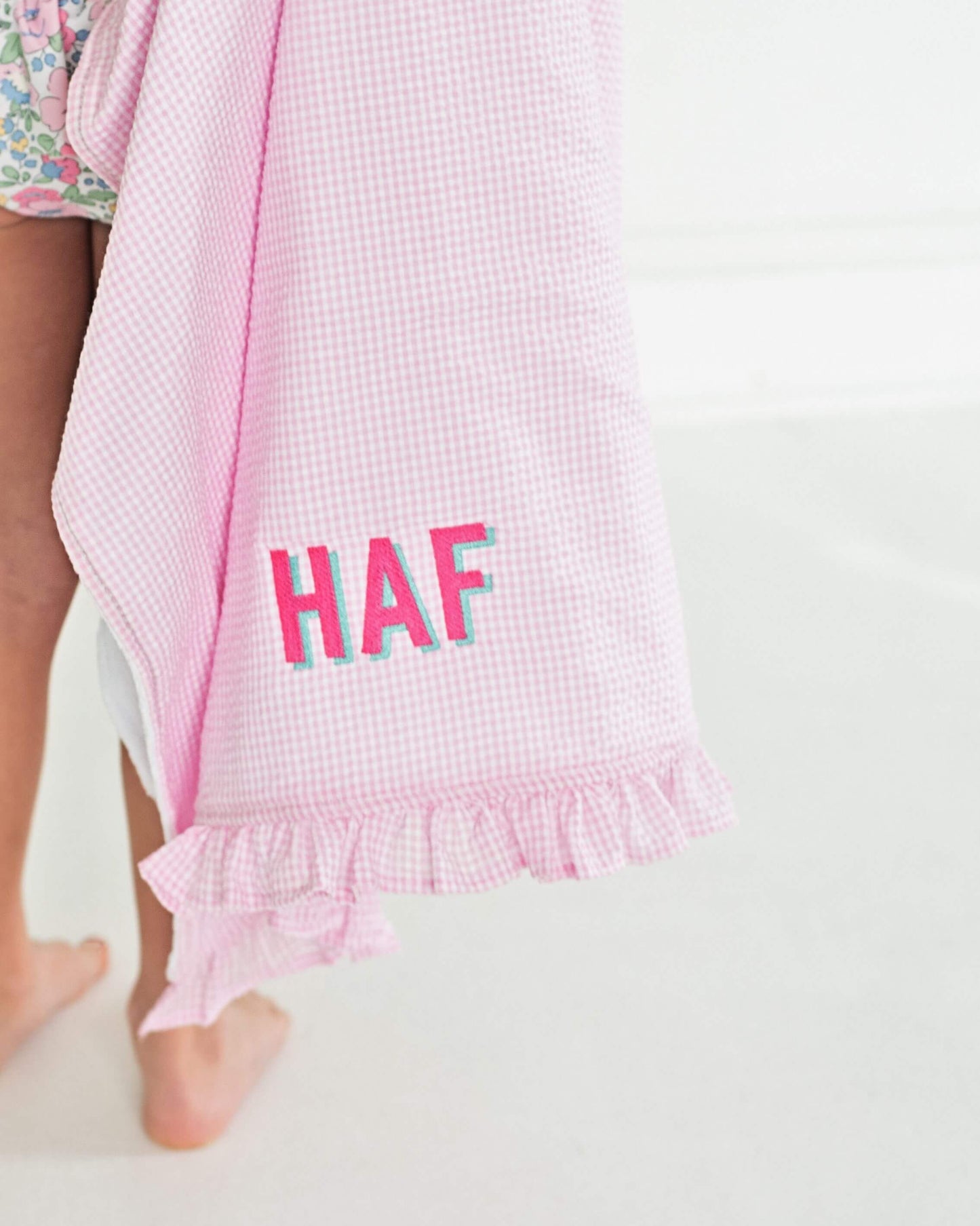 Pink checkered towel with 'HAF' text on a white background