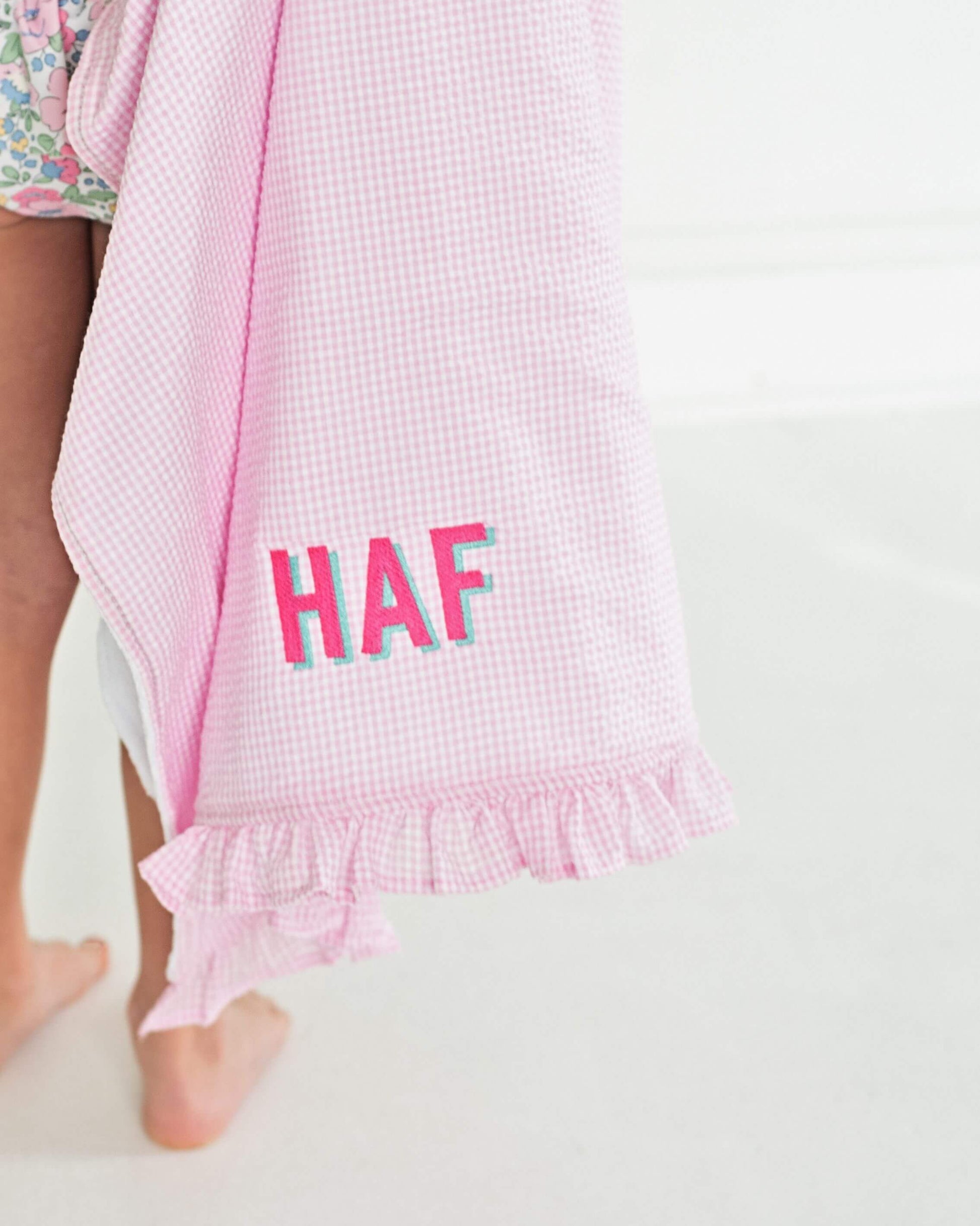 Pink checkered towel with 'HAF' text on a white background