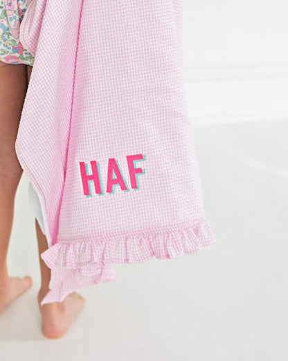 Pink checkered towel with 'HAF' text on a white background