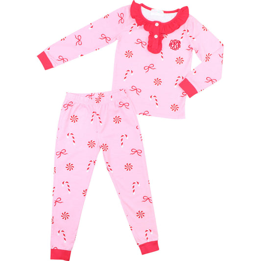 Pink children's pajama set with red candy on a white background