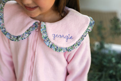 Pink jacket with decorative collar and embroidered name 'Georgie' on a blurred background