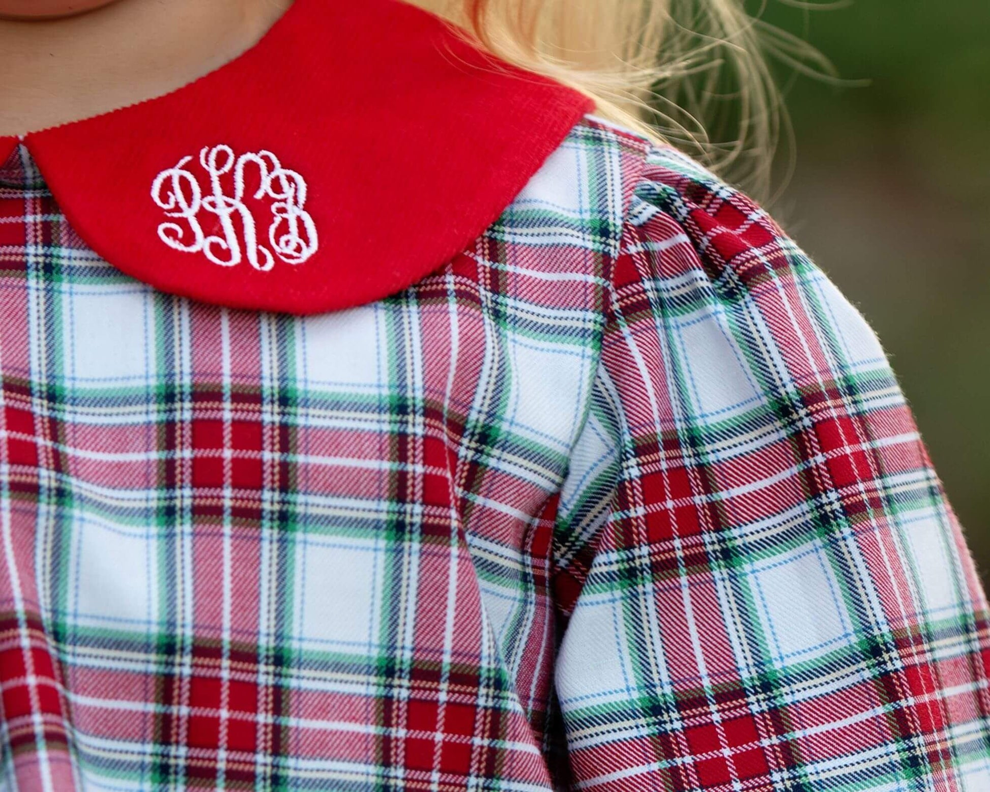 Plaid shirt with red collar and monogram, blurred background
