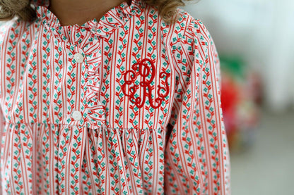 Red and white patterned dress with monogram on a blurred background