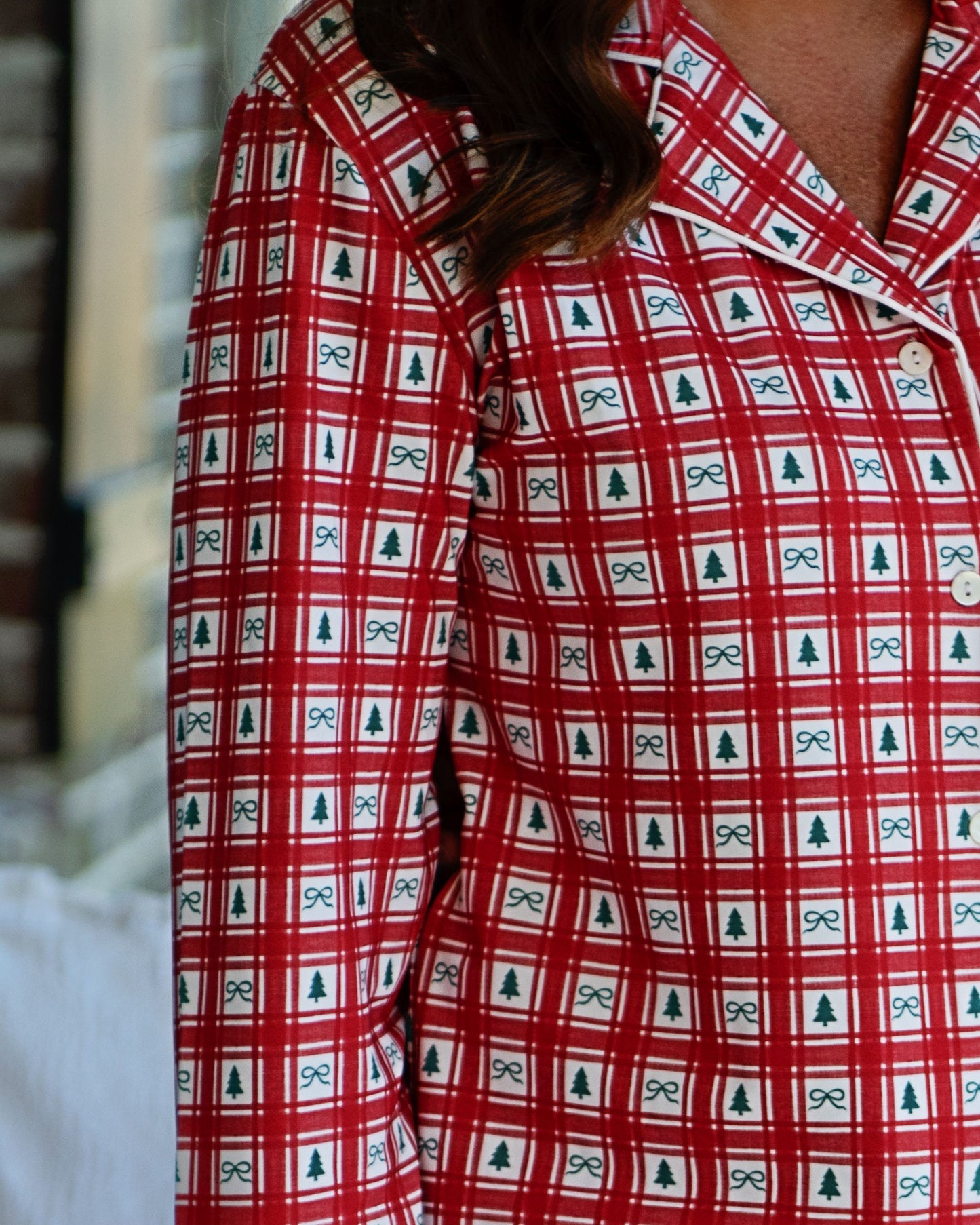 Red checkered shirt with bow and tree pattern worn by a person