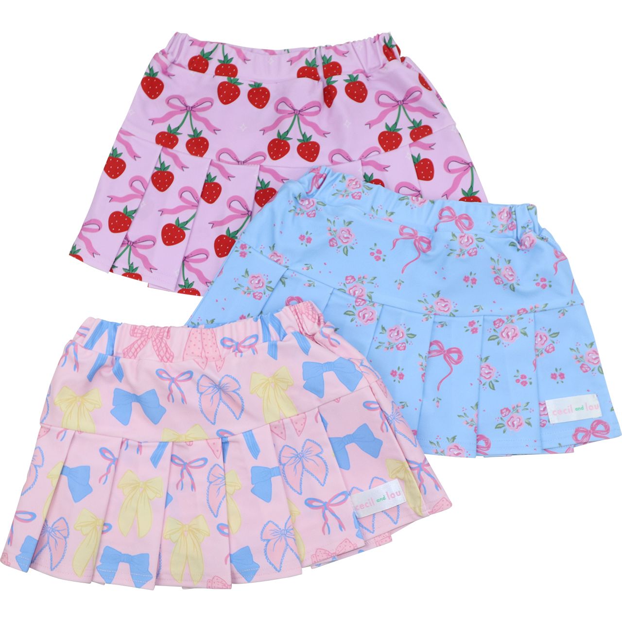 Set of three children's skirts with strawberry, floral, and butterfly patterns on a white background.