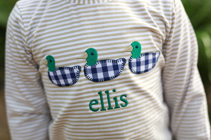 Striped shirt with duck designs and the name 'ellis' on a blurred green background