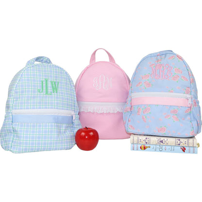 Three children's backpacks with monograms and a red apple on a white background
