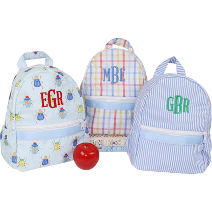 Three children's backpacks with monograms on a white background