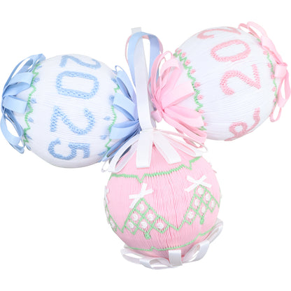 Three decorative balls with smocked numbers on a white background