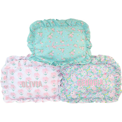 Three floral-patterned zip pouches with monogramming on a white background