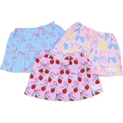 Three pairs of children's skirts with different patterns on a white background