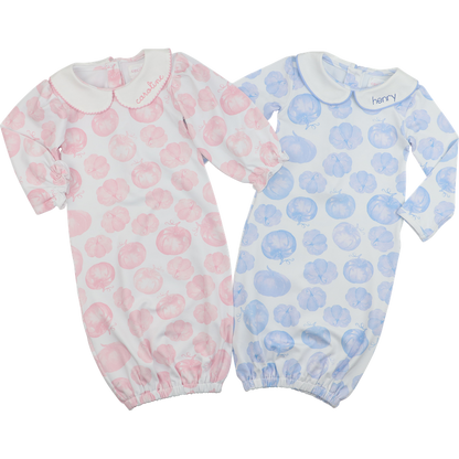 Two baby onesies with pink and blue pumpkin patterns on a white background