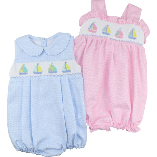 Two baby rompers, one blue and one pink, with sailboat embroidery on a white background.