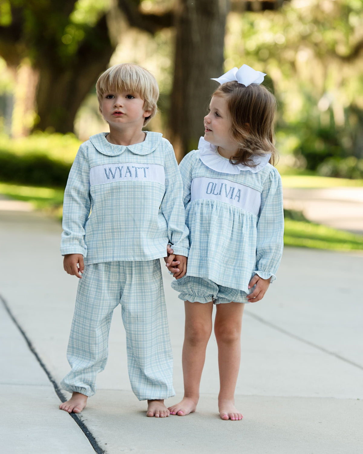 Boy and girl wearing coordinating blue plaid fall and winter outfits outdoors